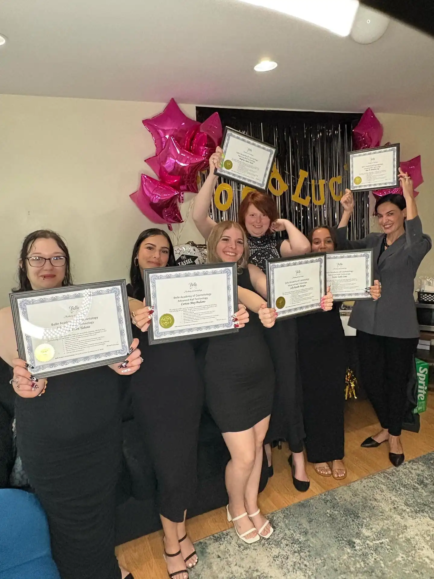Graduate with instructor celebrating certificate at Belle Academy