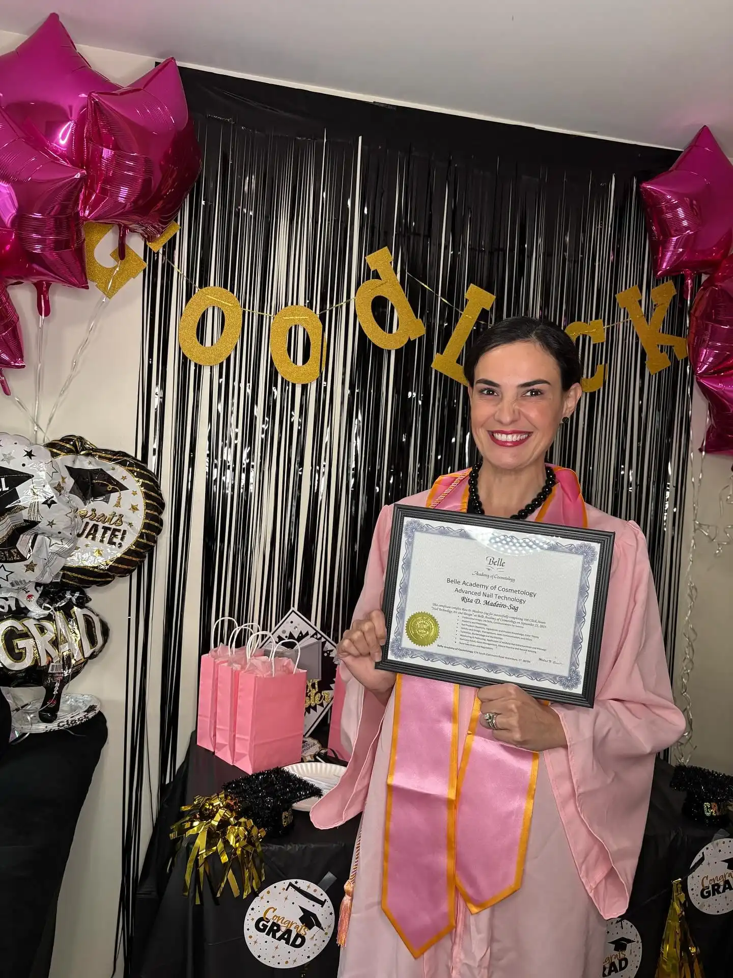 Belle Academy graduate with instructor holding diploma
