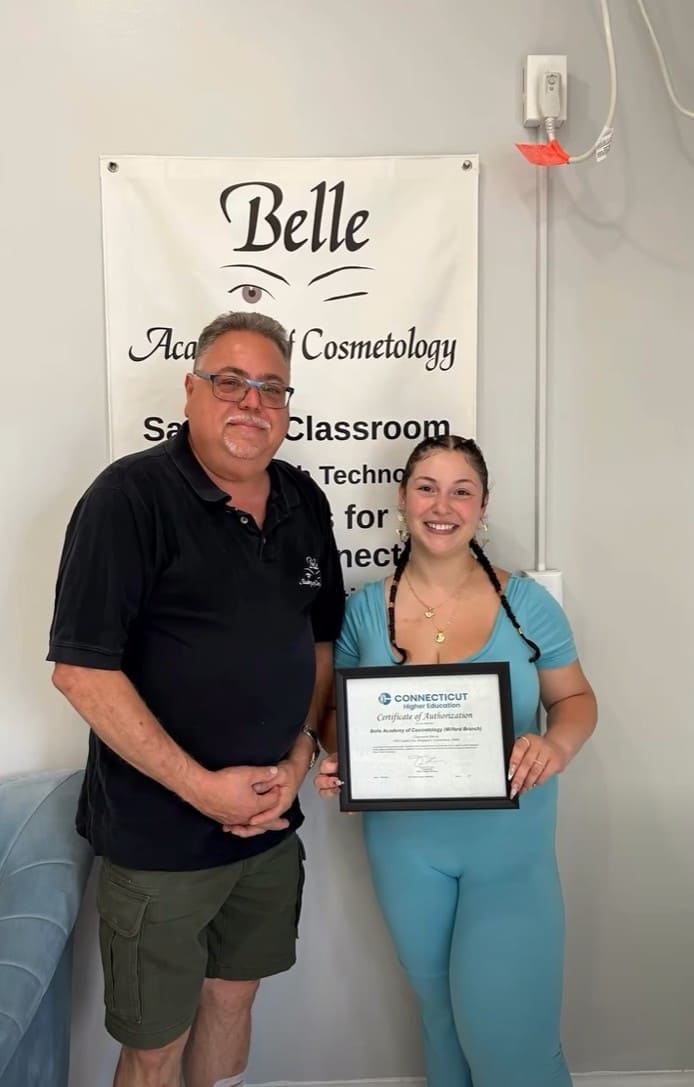 Belle Academy instructor presenting certificate to graduate