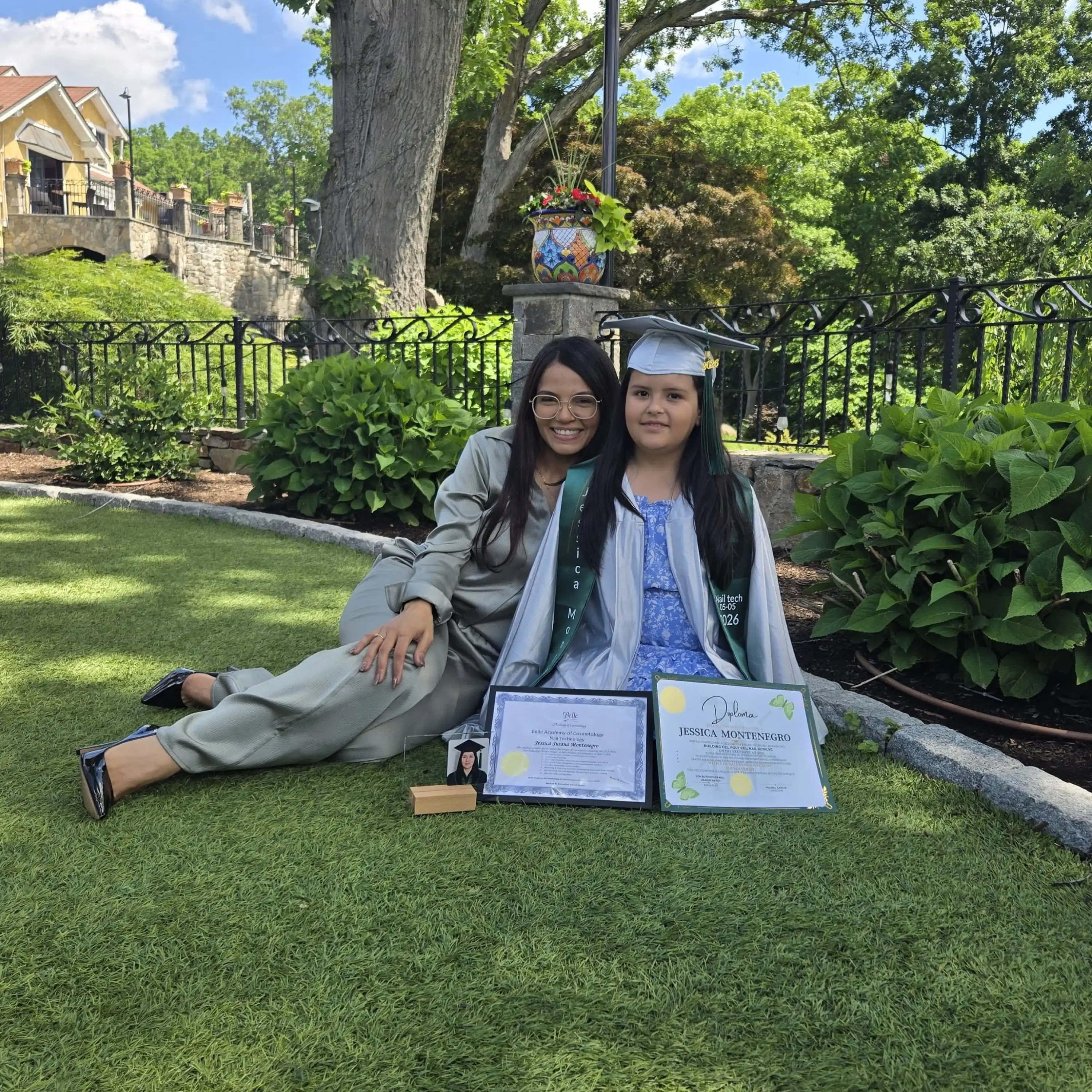 Belle Academy graduates seated outdoors with certificates