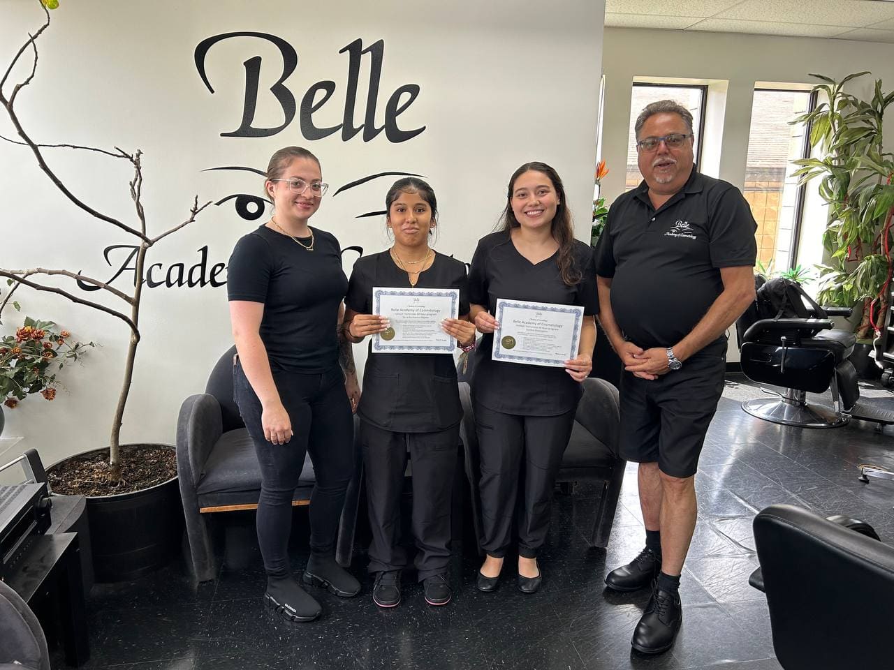 Nail tech graduates with instructors at Belle Academy